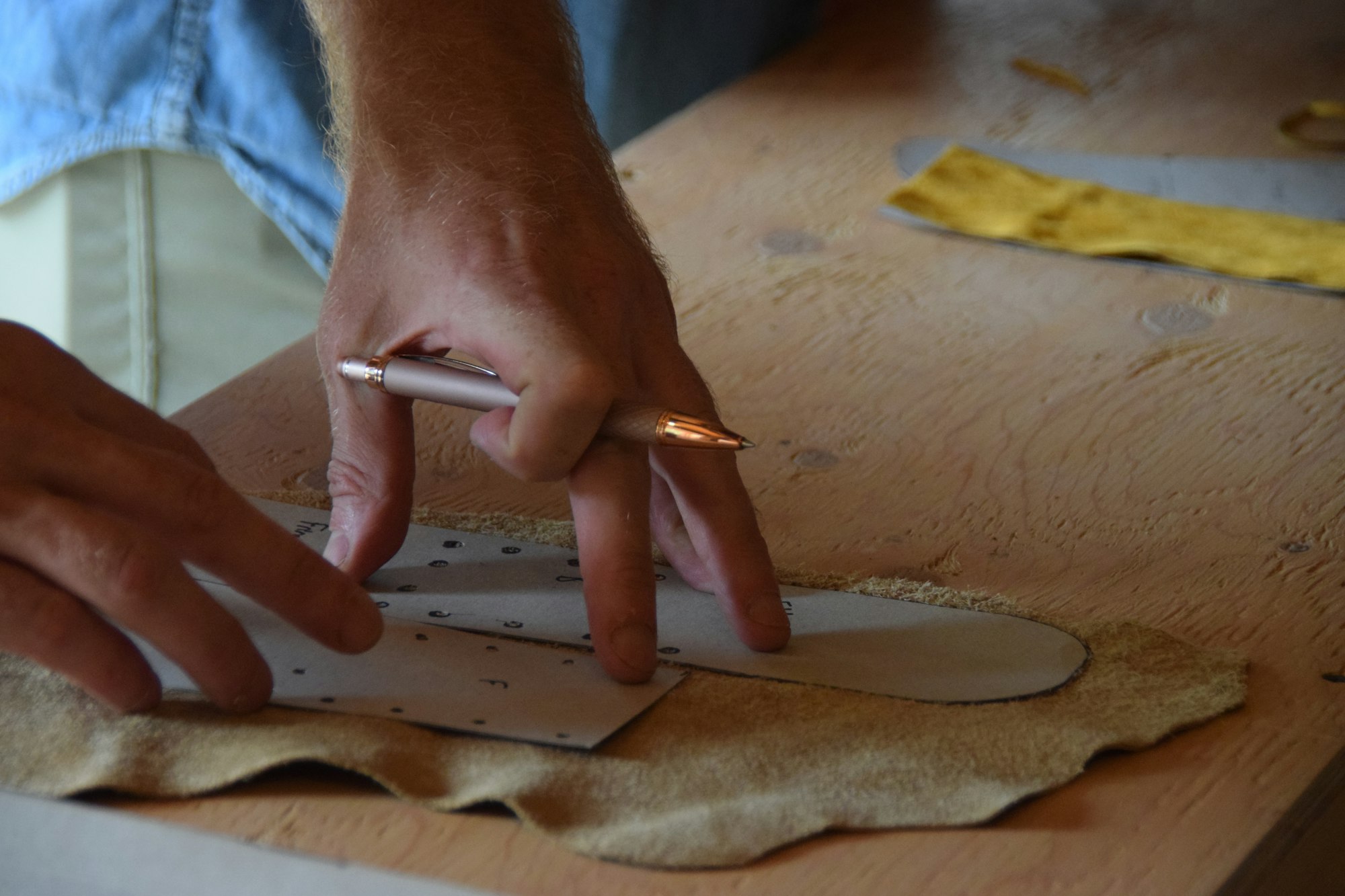 Artesano trazando un patron sobre cuero