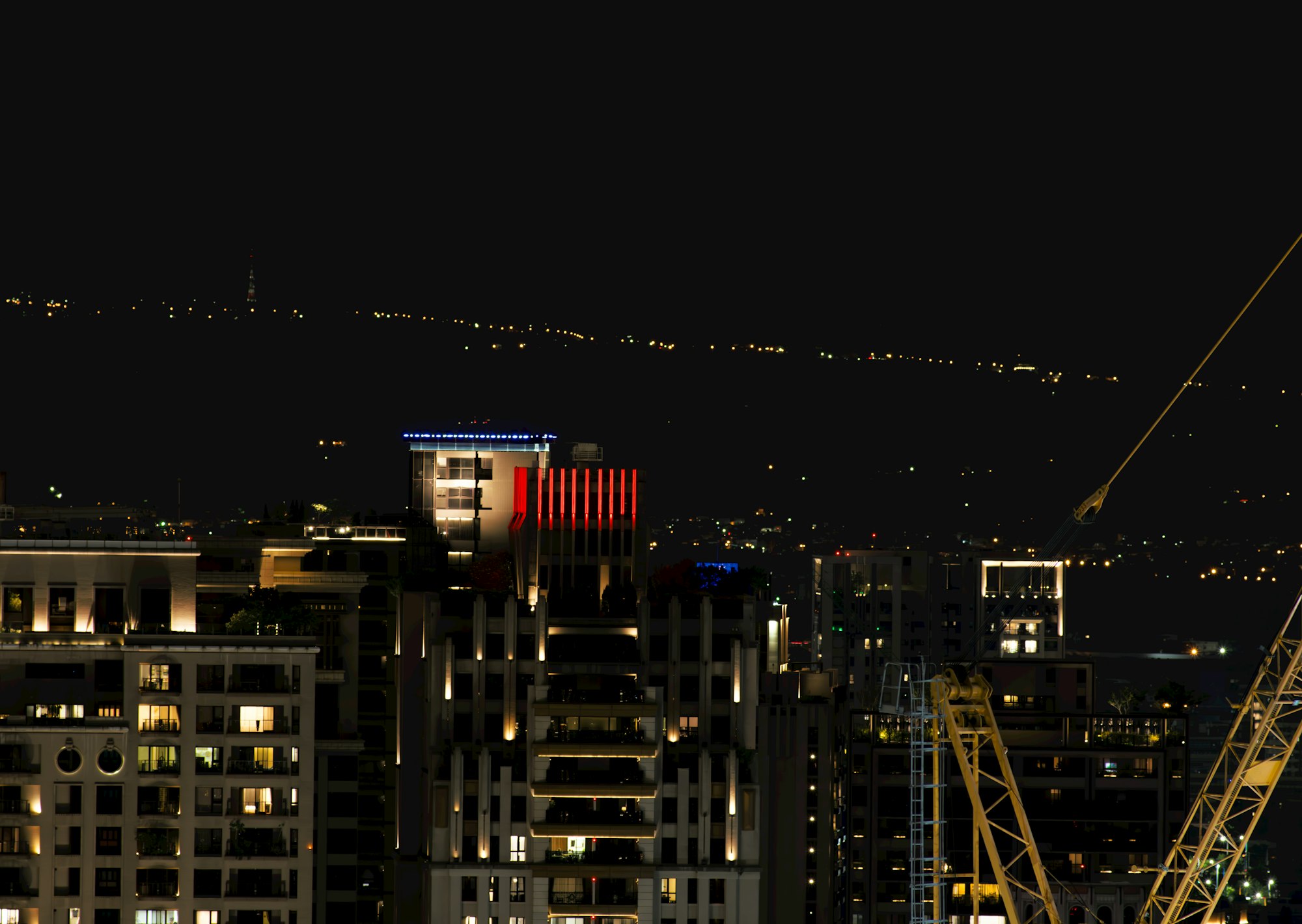 Gruas de construccion sobre la ciudad de noche